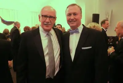 Two men standing and smiling together for a photo